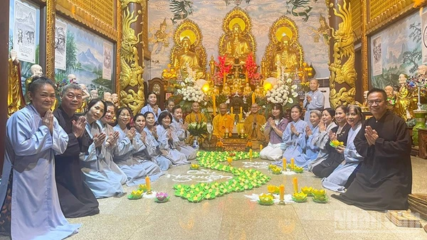 Cộng đồng người Việt Nam tại Lào thắp nến hoa đăng cầu nguyện cho đồng bào. (Ảnh: DUY TOÀN)