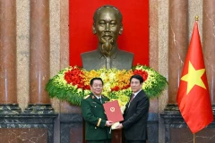 Chủ tịch nước Lương Cường trao quyết định và tặng hoa chúc mừng đồng chí Nguyễn Trọng Nghĩa. (Ảnh: THỦY NGUYÊN)