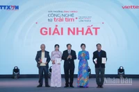 Tổng Giám đốc TTXVN Vũ Việt Trang, Chủ tịch Hội đồng Giải thưởng và Thứ trưởng Bộ Văn hóa, Thể thao và Du lịch Tạ Quang Đông trao giải Nhất cho các tác giả. (Ảnh: THANH GIANG)