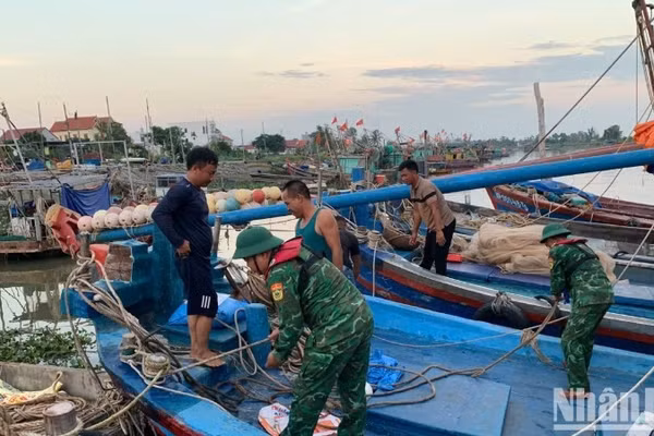 Cán bộ, chiến sĩ Đồn Biên phòng Đoàn Xá hỗ trợ ngư dân chằng buộc phương tiện phòng, chống bão Ragasa.