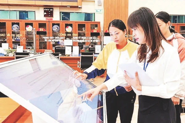 Cán bộ hướng dẫn người dân làm thủ tục hành chính tại bộ phận một cửa.