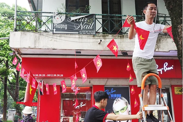Người dân phường Hoàn Kiếm treo cờ đỏ sao vàng đón ngày đại lễ. Ảnh: ANH QUÂN