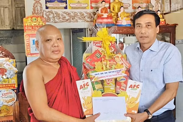 Đồng chí Hồ Văn Linh, Bí thư Đảng ủy xã Hòa Bình, tặng quà Tết cho Thượng tọa Danh Dần, trụ trì chùa Hòa Bình mới.