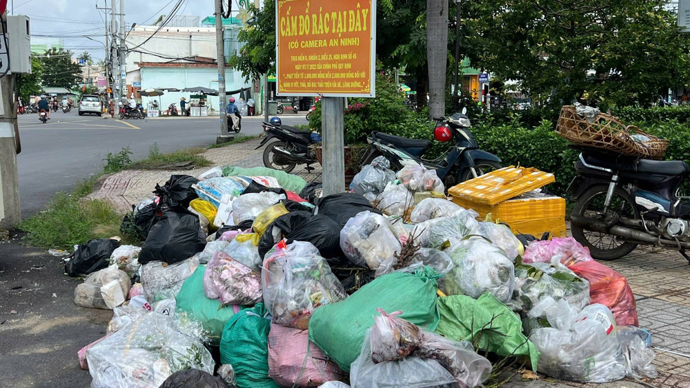 Rác tràn ra lề đường tại xã Ba Tri (tỉnh Vĩnh Long) do không được thu gom, vận chuyển về bãi rác. (Ảnh: HOÀNG TRUNG)