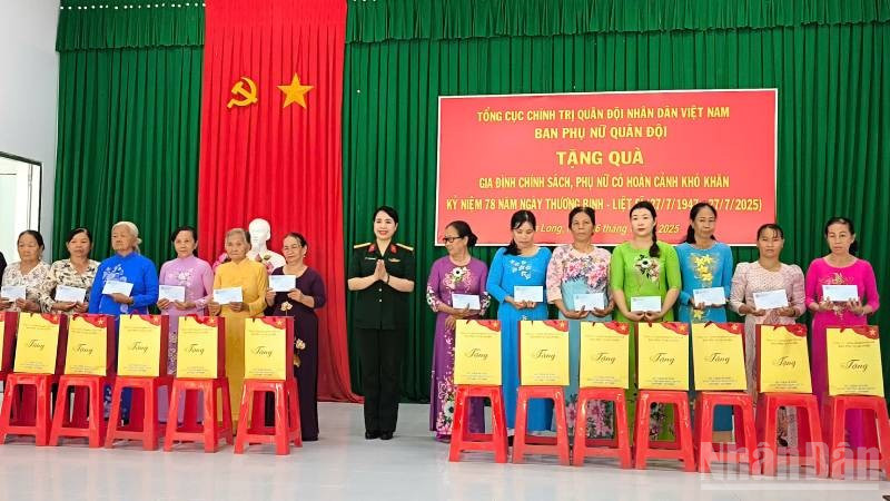 Đại tá Nguyễn Thị Thu Hiền, Trưởng Ban Phụ nữ Quân đội trao quà cho phụ nữ có hoàn cảnh khó khăn tại xã Lương Hòa. (Ảnh: HOÀNG TRUNG) ndo_br_pn.jpg