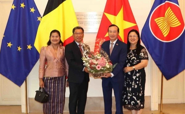 Đại sứ Kingphokeo Phommahaxay (trái) tặng hoa cho Đại sứ Nguyễn Văn Thảo. (Ảnh: HƯƠNG GIANG/TTXVN)