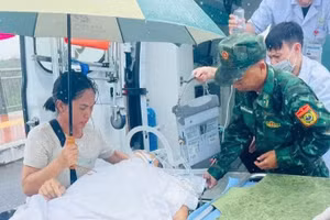 Bộ đội Biên phòng Quảng Ninh (Việt Nam) hỗ trợ đưa các bệnh nhân xuất cảnh sang Đông Hưng (Trung Quốc). (Ảnh: QUANG THỌ)