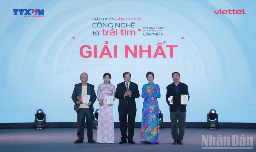 Tổng Giám đốc TTXVN Vũ Việt Trang, Chủ tịch Hội đồng Giải thưởng và Thứ trưởng Bộ Văn hóa, Thể thao và Du lịch Tạ Quang Đông trao giải Nhất cho các tác giả. (Ảnh: THANH GIANG)