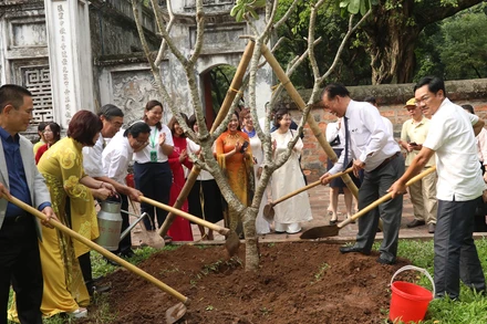 Các đại biểu trồng cây lưu niệm tại Văn Miếu - Quốc Tử Giám. (Ảnh: Ban tổ chức)