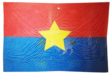 Cờ Mặt trận do nữ tù chính trị Côn Đảo may và thêu khi hay tin Hiệp định Paris ký kết. Lá cờ thấm máu tù chính trị được treo trước cửa dinh chúa đảo đúng ngày 1/5/1975.