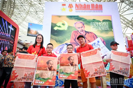 Niềm vui của một gia đình nhỏ khi xếp hàng và nhận được phụ san đặc biệt Báo Nhân Dân. Ảnh: THÀNH ĐẠT