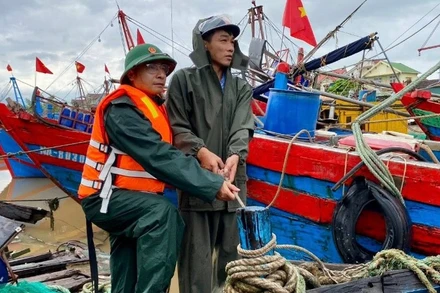 Cán bộ, chiến sĩ Đồn Biên phòng Diễn Thành, Bộ đội Biên phòng tỉnh Nghệ An hỗ trợ ngư dân neo đậu tàu, thuyền để tránh trú bão. 