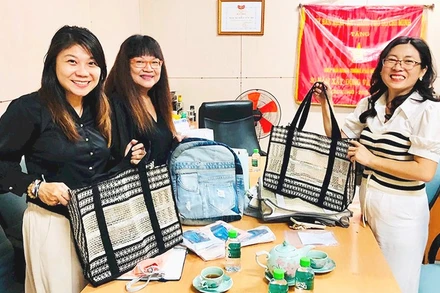 Chị Kim Bình (bên phải) giới thiệu sản phẩm túi lưới tái chế với khách hàng.