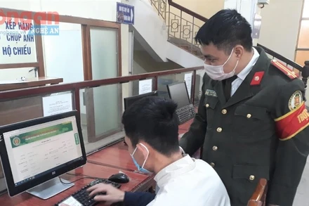 Cán bộ Phòng Quản lý xuất nhập cảnh, Công an tỉnh Nghệ An hướng dẫn người dân hoàn thành các thủ tục hành chính.