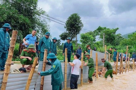 Công an xã Hùng Chân, tỉnh Nghệ An phối hợp chính quyền địa phương và nhân dân khắc phục tuyến đường qua bản Luông bị xói lở do mưa bão gây ra. (Ảnh ĐÌNH PHƯỢNG)