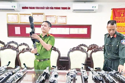 Cán bộ Cục Cảnh sát hình sự khám xét khẩu súng do Ngô Quang Vỹ và đồng phạm chế tạo, mua bán. (Ảnh: Công an cung cấp)