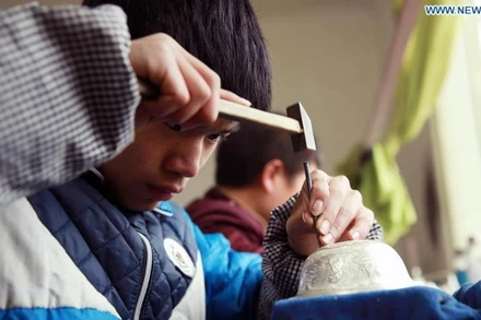 Thợ thủ công chế tác trang sức bạc tại tỉnh Quý Châu, tây nam Trung Quốc. (Ảnh: Xinhua)