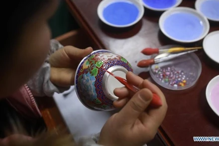Nghệ nhân đang tráng men cho một chiếc bát bạc ở tỉnh Quý Châu, tây nam Trung Quốc. (Ảnh: Xinhua)