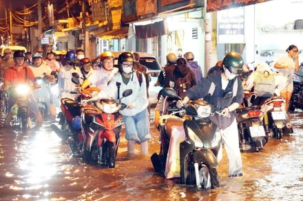 Xe gắn máy phải dắt bộ trên đường Bình Quới, phường Bình Quới, Thành phố Hồ Chí Minh. (Ảnh: TTXVN)