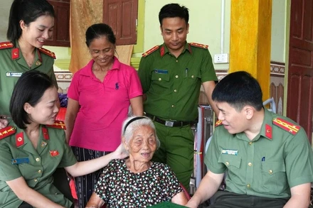 Đại tá Trần Hồng Quang, Phó Giám đốc Công an tỉnh Nghệ An ân cần thăm hỏi sức khỏe Mẹ Việt Nam Anh hùng Nguyễn Thị Năm. (Ảnh: CÔNG AN NGHỆ AN)