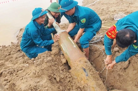 Quả bom phát lộ do bờ sông bị sạt lở trong đợt mưa lũ vừa qua. (Ảnh: TRỌNG KIÊN)