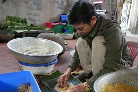 Ông Nguyễn Tất Lớ, làng Thủy Đường, gói bánh. (Ảnh: TTXVN)