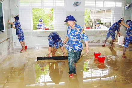 Kéo bùn dọn dẹp phòng học. Ảnh: HẢI LUẬN