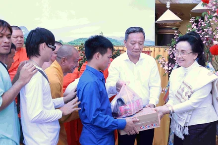 Bà Naly Sisoulith (bìa phải) trao quà cho người dân.