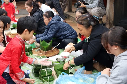 Các bạn nhỏ học cách gói bánh chưng.