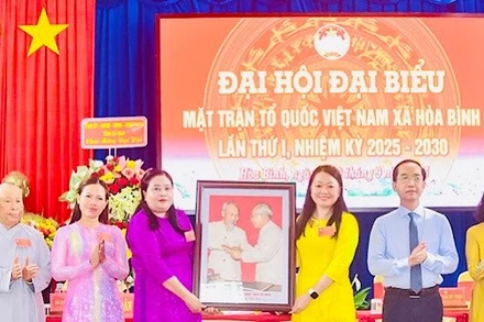 Đồng chí Hồ Thanh Thủy, Phó Bí thư Tỉnh ủy Cà Mau, trao tặng ảnh Bác Hồ và Bác Tôn, chúc mừng Đại hội Ủy ban Mặt trận Tổ quốc Việt Nam xã Hòa Bình. 