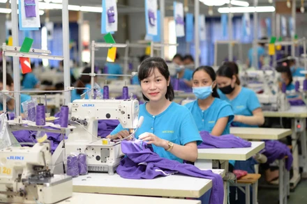 Công nhân nữ làm việc hứng khởi tại cơ sở sản xuất của Tổng công ty Cổ phần Dệt may Hà Nội (Hanosimex).