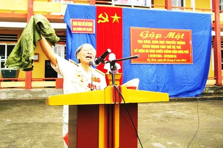 Bác Nguyễn Hưng Canh giới thiệu kỷ vật chiến tranh khi nói chuyện với học sinh tại các trường.