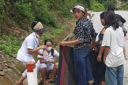 Hai cán bộ Trạm Y tế xã Mường Típ đỡ đẻ cho sản phụ trên đường. (Ảnh: NGỌC MAI)