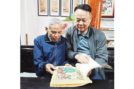 Nghệ nhân Nguyễn Đăng Chế giới thiệu với tác giả bài viết bộ sưu tập tranh dân gian Đông Hồ.
