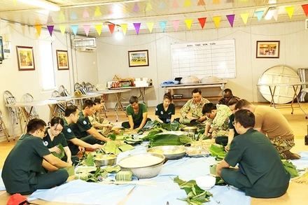 Những người lính Việt Nam tại Phái bộ gìn giữ hòa bình LHQ ở Nam Sudan gói bánh chưng đón Tết. Ảnh: TIẾN PHÚC