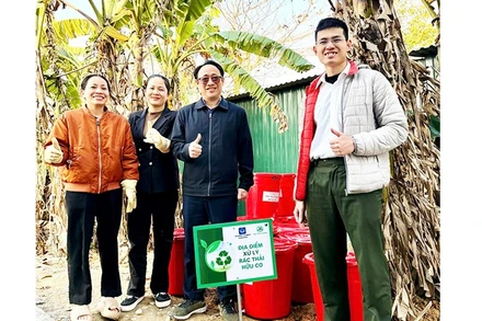 Trung úy Phạm Minh Hiếu (ngoài cùng bên phải) hướng dẫn người dân ủ rác hữu cơ thành phân bón vi sinh Bokashi.