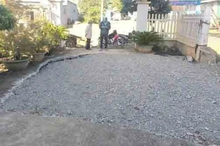 Khu vực sân của một hộ dân bị sụt lún đã được đổ đất đá trám lại.