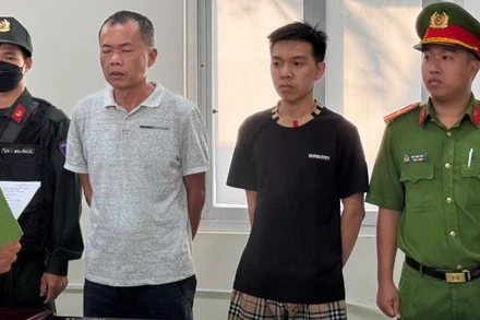 Đặng Trần Quốc Vũ (áo trắng) và Đào Năng Nghĩa (áo đen) tại cơ quan Công an. 