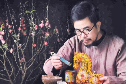 Nghệ nhân Nguyễn Tấn Phát trong quá trình sáng tạo tác phẩm sơn mài ngựa Bính Ngọ 2026. (Ảnh MINH NGUYỄN)