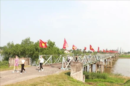Du khách quốc tế tham quan cầu Hiền Lương - sông Bến Hải thuộc Di tích quốc gia đặc biệt Đôi bờ Hiền Lương - Bến Hải, tỉnh Quảng Trị. (Ảnh: TTXVN)