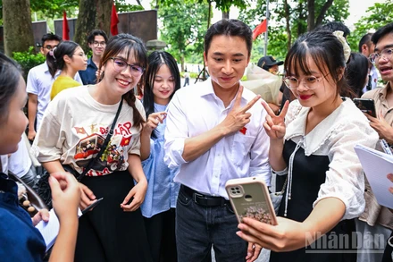 Phan Mạnh Quỳnh trong vòng vây người hâm mộ tại tòa soạn Báo Nhân Dân. (Ảnh: THÀNH ĐẠT)