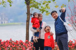 Cả gia đình cùng nhau ghi lại khoảnh khắc của mùa Xuân bên hồ Gươm. (Ảnh: Thanh Tùng/TTXVN)