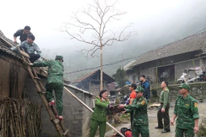 Các lực lượng chức năng hỗ trợ người dân xã biên giới Tùng Vài khắc phục hậu quả thiên tai.