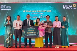 Đại diện lãnh đạo Ngân hàng Nhà nước Việt Nam khu vực 8, BIDV Hà Tĩnh, chính quyền địa phương tặng hoa chúc mừng khách hàng may mắn.