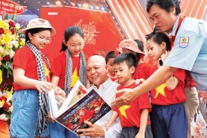 Nghệ sĩ nhiếp ảnh Nguyễn Á (áo trắng) giới thiệu sách ảnh tới công chúng.