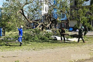 Bộ đội cùng công nhân vệ sinh môi trường tỉnh Gia Lai cắt tỉa cây bị đổ gãy, thông thoáng đường đi cho người dân.