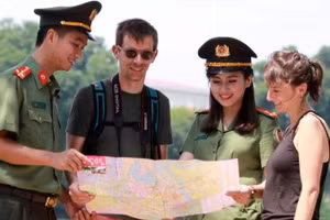 Chiến sĩ Công an thành phố Hà Nội hỗ trợ khách du lịch nước ngoài tham quan Thủ đô. (Ảnh: Lam Thanh)