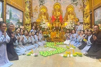 Cộng đồng người Việt Nam tại Lào thắp nến hoa đăng cầu nguyện cho đồng bào. (Ảnh: DUY TOÀN)