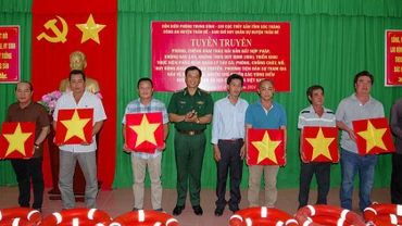 Tặng cờ Tổ quốc và phao cứu sinh cho ngư dân.