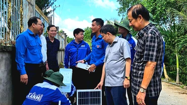 Các chiến sĩ tình nguyện thực hiện lắp trụ đèn chiếu sáng của công trình “Thắp sáng đường quê”.